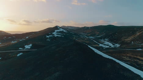 Photographer-capturing-stunning-Grindavíkurbær-overlooking-Grindavik-mountain-valley-landscape-at-sunrise,-Aerial-view