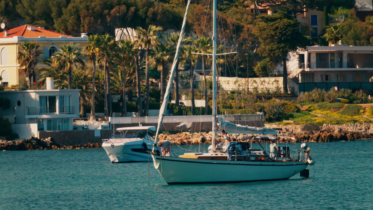 Boats docked on the sea with villas surrounded by greenery in the background