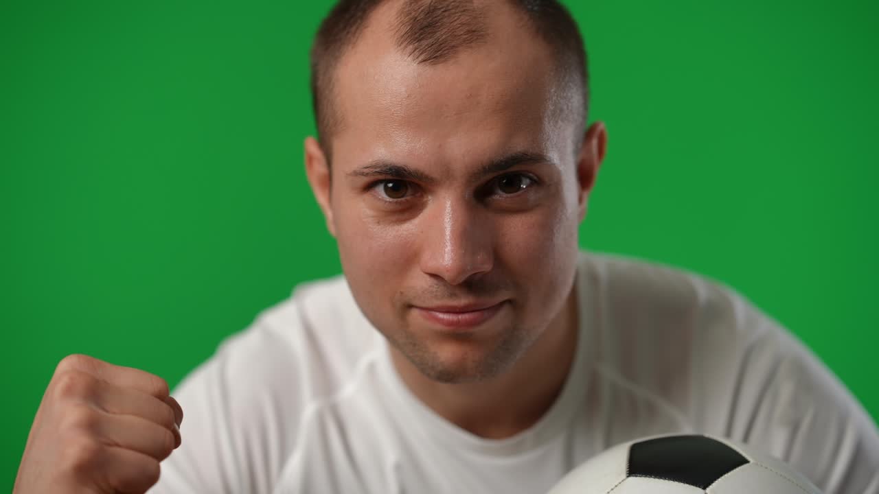 Successful sportsman leaning to camera gesturing yes smiling on green screen. Portrait of satisfied excited Caucasian young man looking at camera posing at chromakey background. Championship.