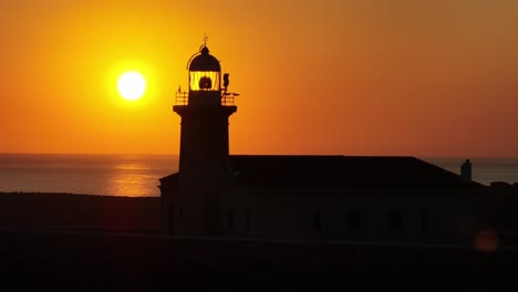 el sol del faro de fano de punta nati en menorca, españa