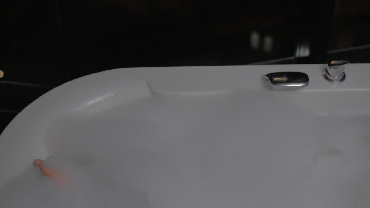 욕조에서 휴식을 취하고 태블릿 pc를 사용하는 여성