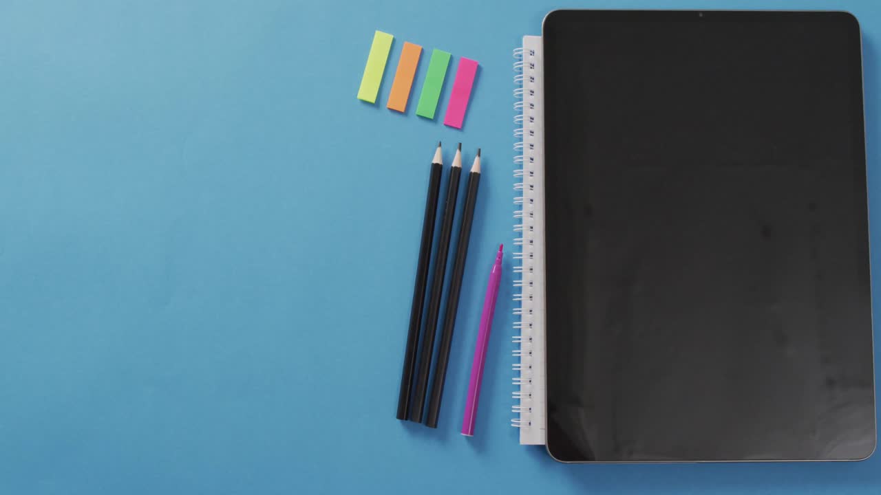 Video of school supplies, notebook, pens, marker pen over blue background