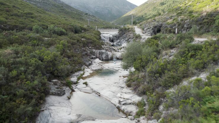 Un volo ipnotizzante in una valle rocciosa sopra una serie di laghi a cascata, Portogallo