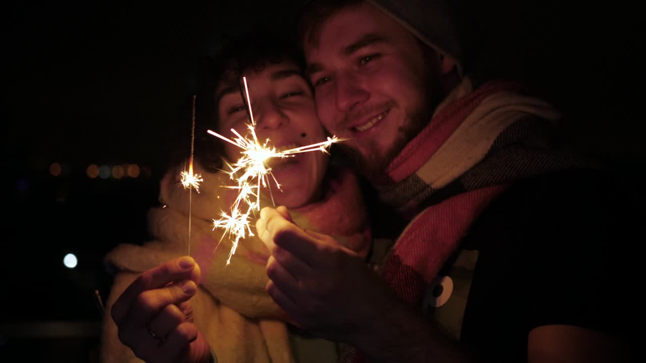 pareja feliz enamorada de chispas abrazándose sonriendo besándose jóvenes
