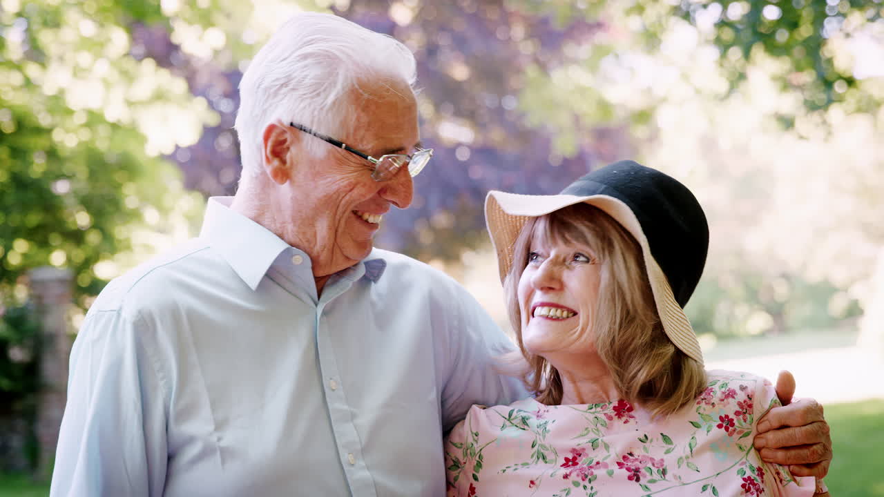 여름 산책 중 야외에서 미소 짓는 고령 부부의 초상화