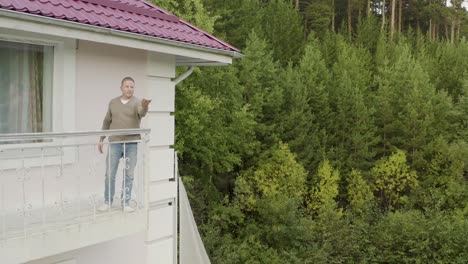 man on balcony overlooking forest