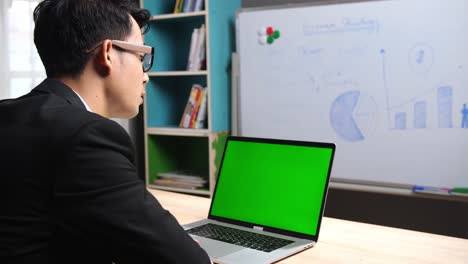 Back Of Businessman Talking With Green Screen Laptop