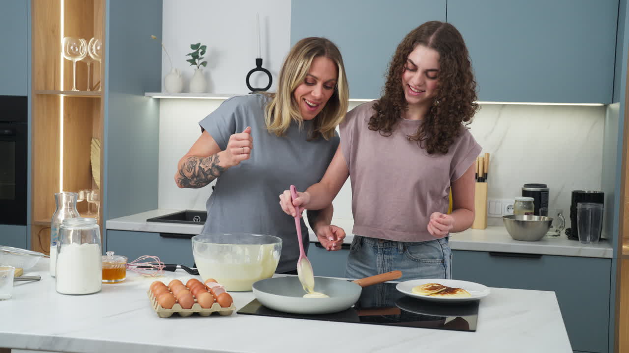 Pretty young ladies carefully making pancakes in the morning