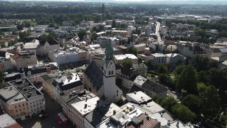 aerial shot of the city rosenheim flying towards theneo-gothic st. nikolaus church showing more detailof the old beautiful building and ending in a top downscenario with a good view of the roof
