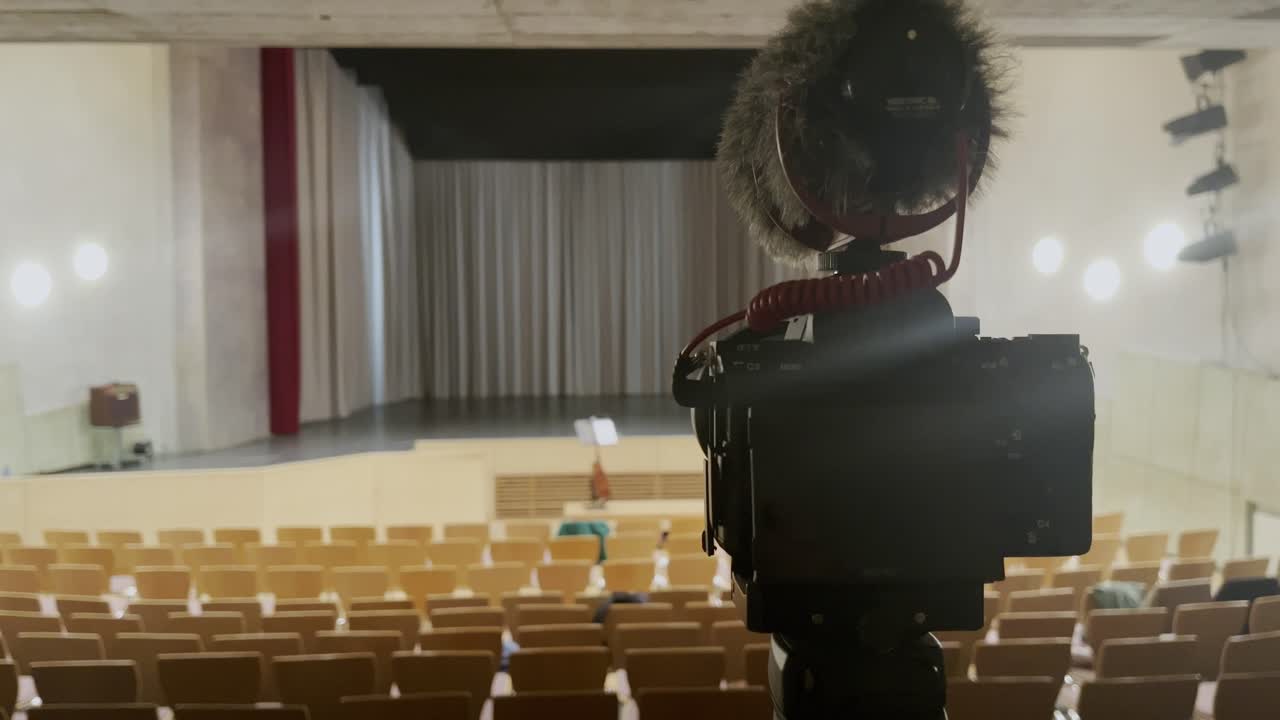 la telecamera è spenta in una stanza vuota di fronte a un palco libero senza persone