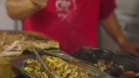 chef prepare fast food with french fries in local truck, close up