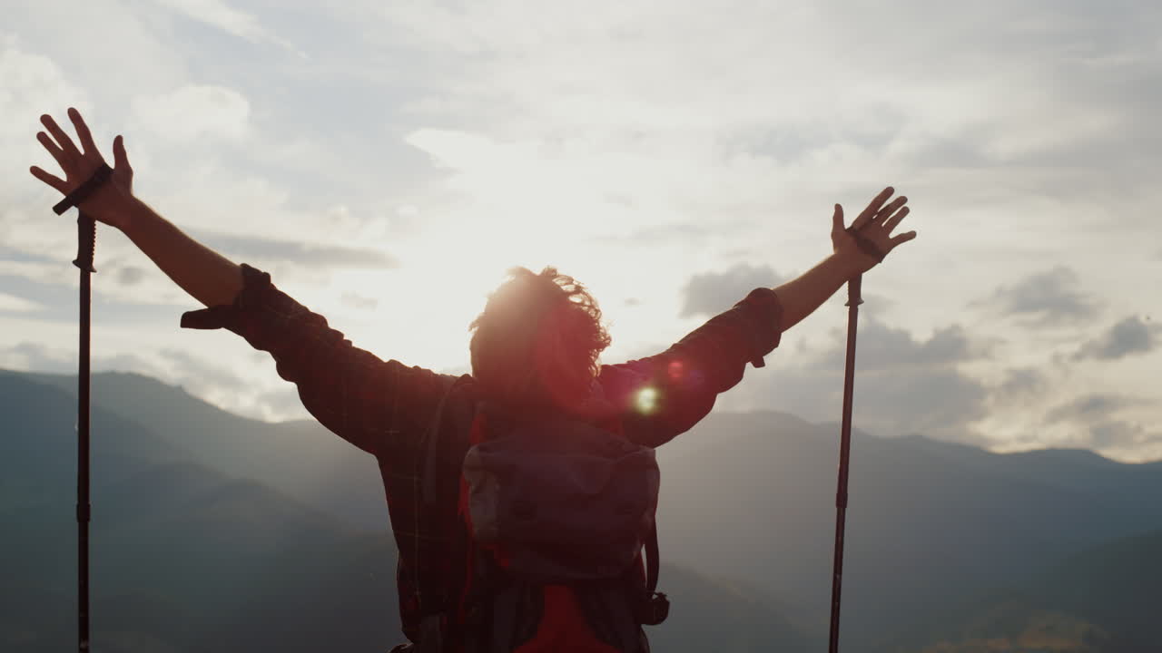 el excursionista alegre levanta las manos a las montañas, el cielo, los turistas celebran la libertad de cerca.