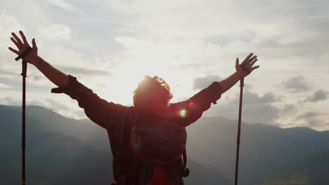 joyful hiker raise hands to mountains sky. tourist celebrate freedom close up.