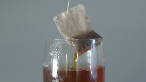 Tea-bag-being-pulled-out-and-put-back-into-cup-of-tea-in-slow-motion