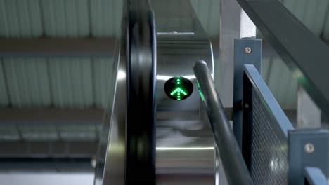 green arrow pointing upwards to access the escalator at a train station in bangkok, thailand