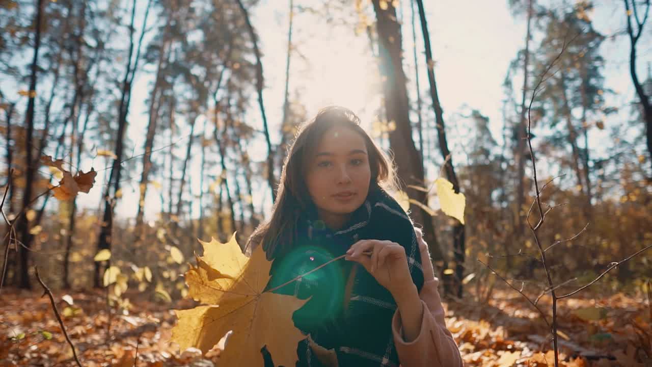 숲 에서 가을 잎 을 즐기는 여자