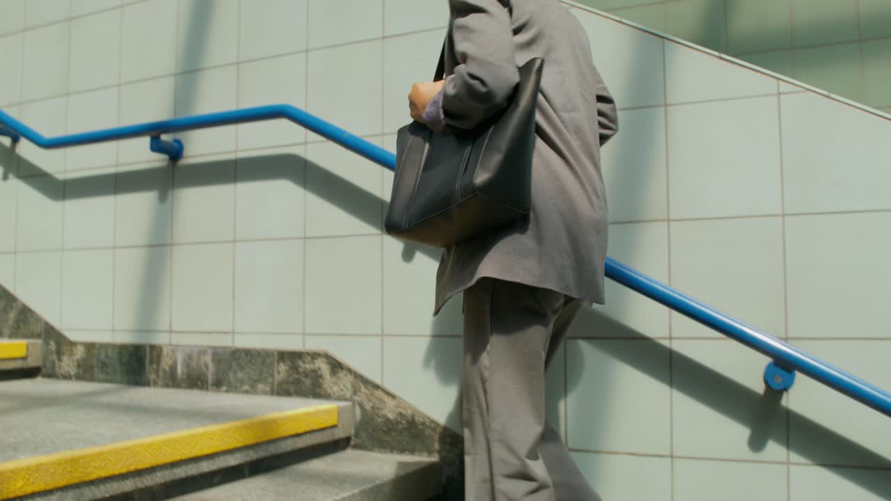mujer caminando por las escaleras de la estación de metro