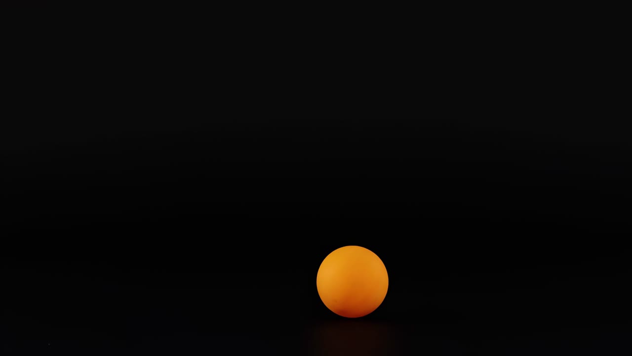 An orange sphere moves vertically against a dark background in a rhythmic sequence.