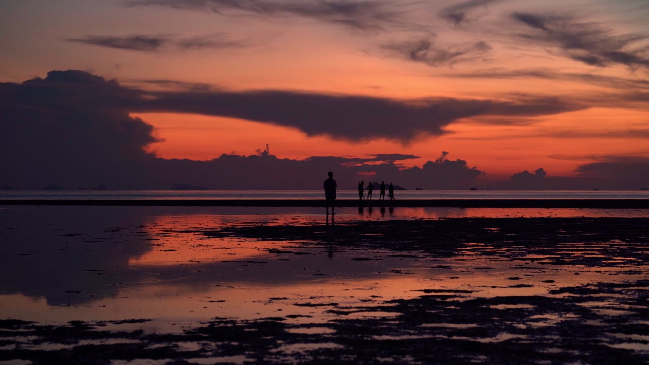 Silhouettes of People on Beach at Sunset