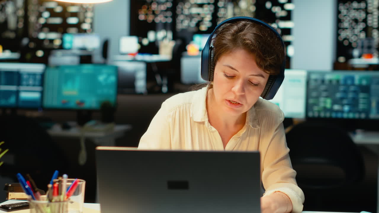 Vertical Video Woman joining a remote webinar from desk using laptop and headset