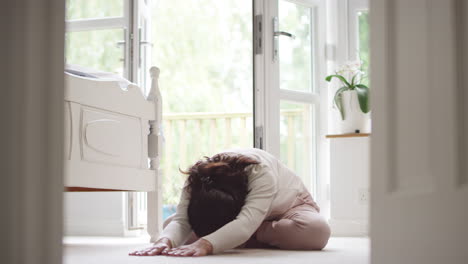 Mujer-Asiática-Madura-En-Pijama-Sentada-En-El-Suelo-Del-Dormitorio-Meditando-En-Pose-De-Yoga---Filmada-En-Cámara-Lenta