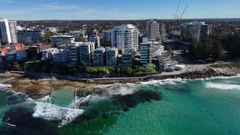wide aerial establishing of cronulla shoreline with crashing waves, buildings and ocean, sydney nsw australia