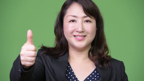 mature beautiful asian businesswoman giving thumbs up