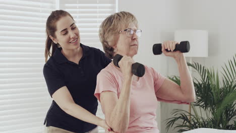 a female physical therapist helping an elderly