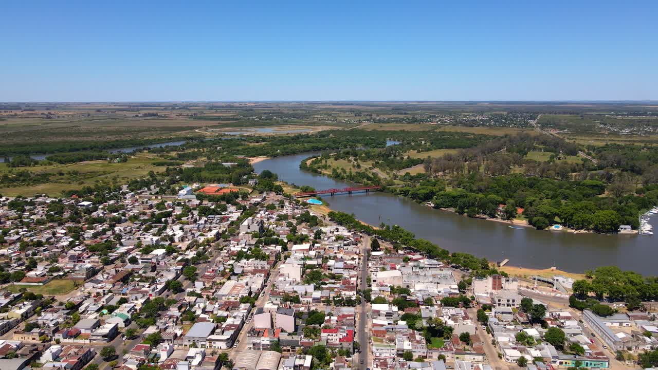 Drone shot flying over Gualeguaych&uacute;, Entre R&iacute;os, Argentina towards the R&iacute;o Gualeguaych&uacute; on a clear, sunny day