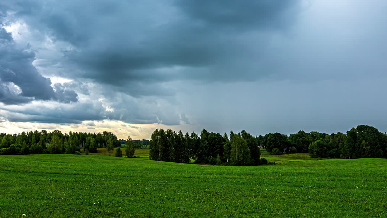 Lapso de tiempo de nubes de lluvia cubriendo un paisaje verde