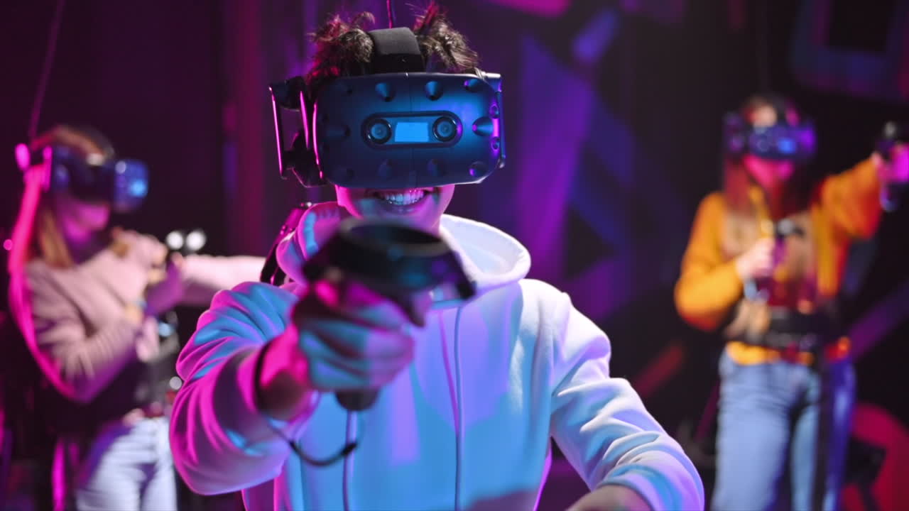 Un bambino allegro e interessato gioca su un tapis roulant VR con casco, controller e uno zaino. Altre persone giocano nelle vicinanze. Rallentatore