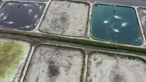 drone flying across aquaculture farming controlled facility, cultivating aquatic organisms for seafood production for human consumption, aerial drone shot birds eye view at manjung perak malaysia