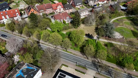 luxury villa with solar panels at road and park area during sunny day in spring season. aerial top down flyover. german small city in april. american neighborhood with single family houses. pa, usa.