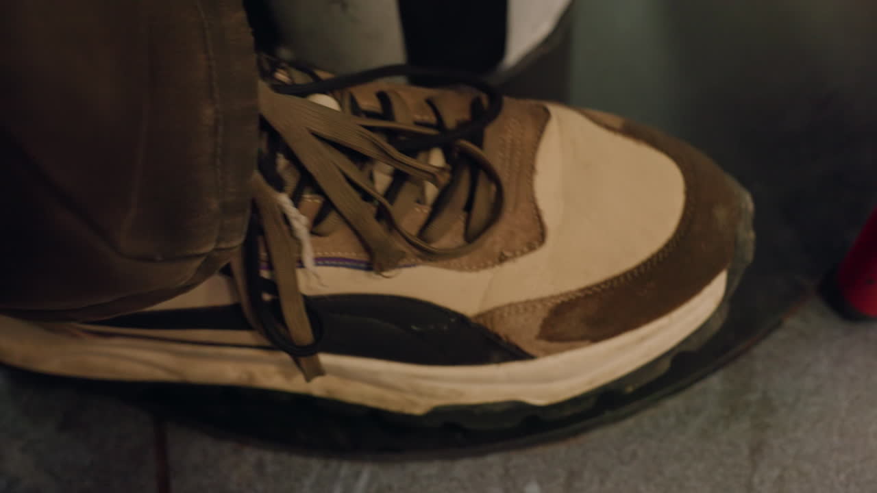 Calzature sportive eleganti in un ambiente accogliente. Vista focalizzata di una scarpa casual con illuminazione ambientale calda. Prospettiva ravvicinata di una sneaker con materiali testurizzati e atmosfera domestica rilassata