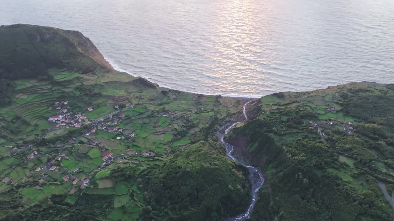 Tilt up shot of Faj&atilde;zinha town during sunset at Flores island Azores, aerial