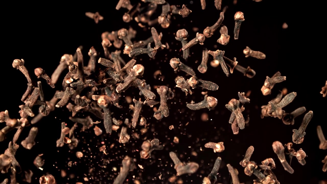 Dried Cloves Falling in Super Slow Motion on Black Background