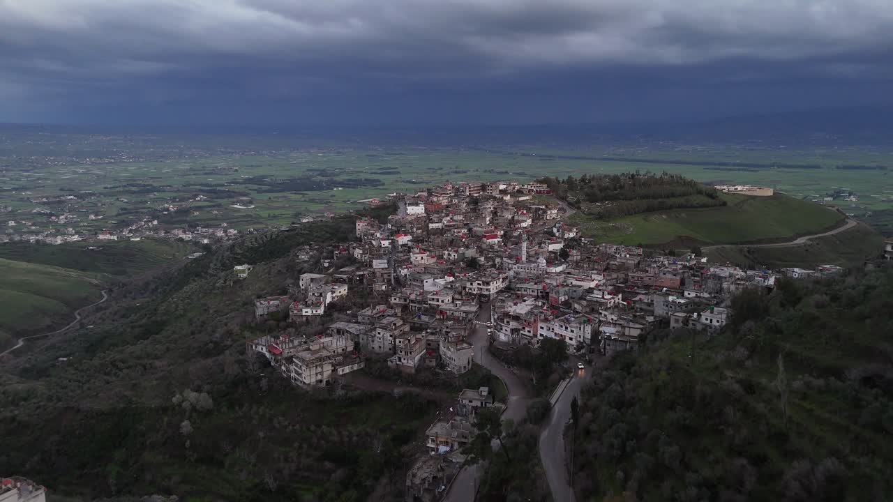 Vista cinematográfica en picado del paisaje rural de Siria, mostrando campos agrícolas y belleza natural bajo un cielo nublado.