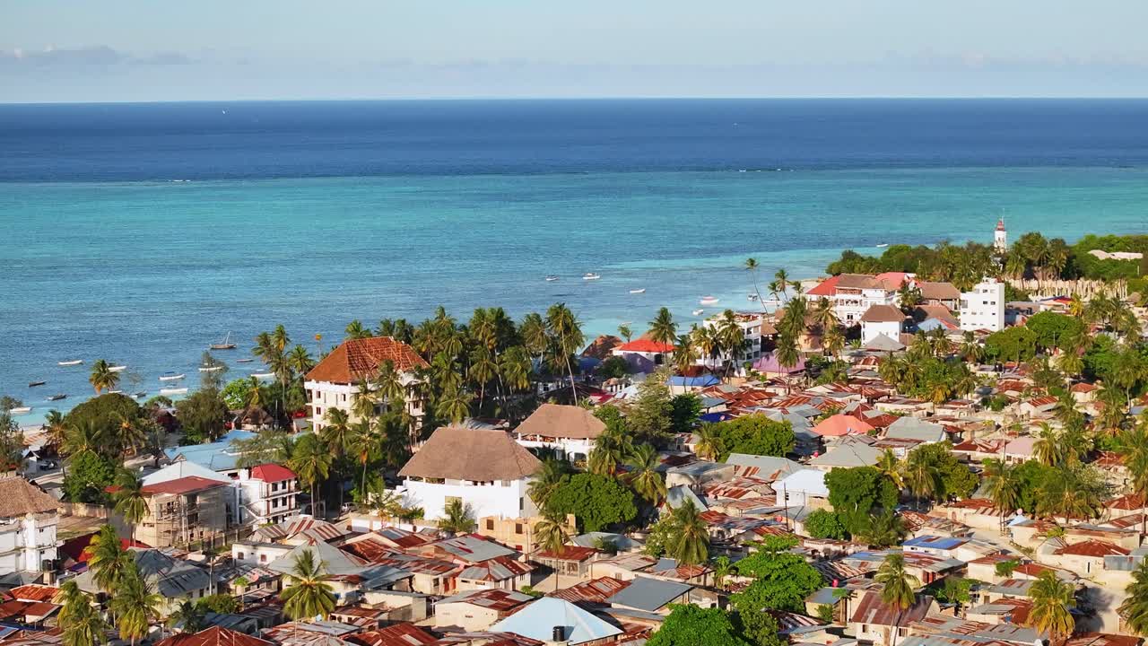 Ripresa cinematografica con drone e zoom 3x che sorvola Nungwi a Zanzibar. La vista aerea dettagliata della costa tropicale, della sabbia bianca e della vita sull'isola crea una scena di viaggio straordinaria e coinvolgente per i progetti turistici