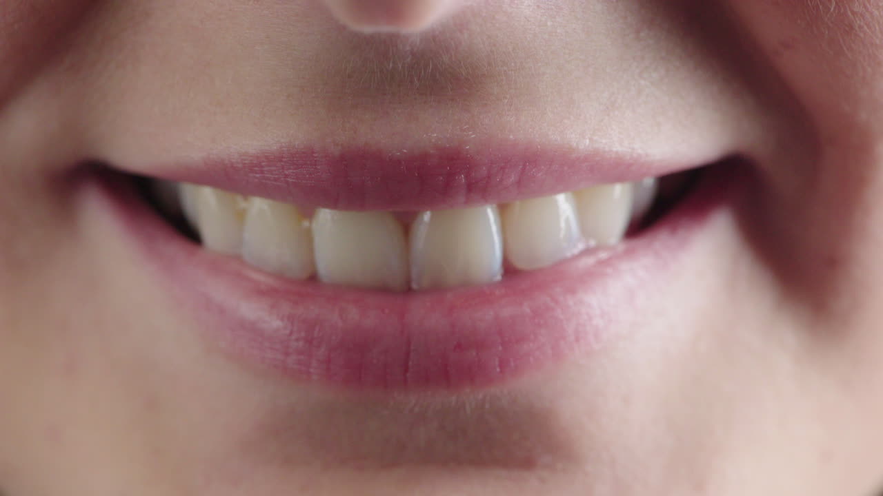 cerca de la boca de la mujer sonriendo labios suaves que muestran dientes blancos sanos