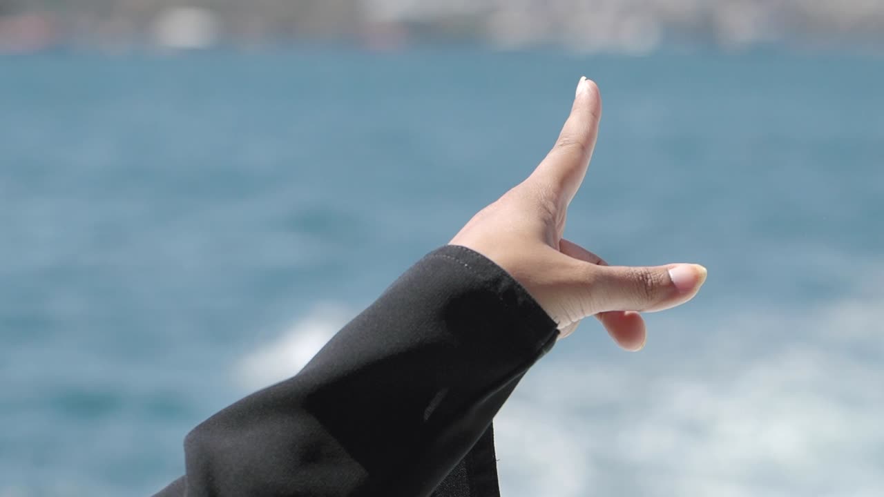 Hand pointing towards the ocean
