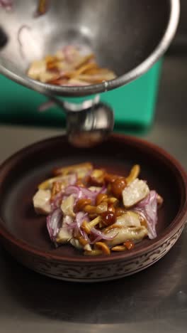 chef preparing a dish of marinated fish and mushrooms