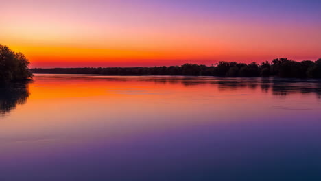 vibrant sunset over a calm river with reflective waters