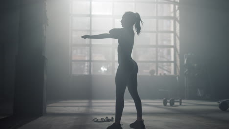 woman doing stretching exercises in sport club. female athlete warming hands