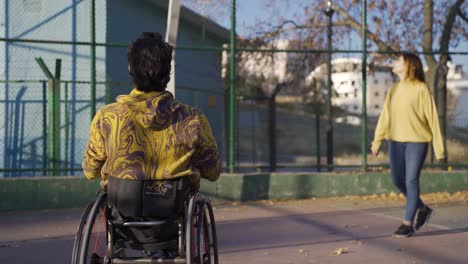 un adolescente discapacitado en silla de ruedas jugando al baloncesto.