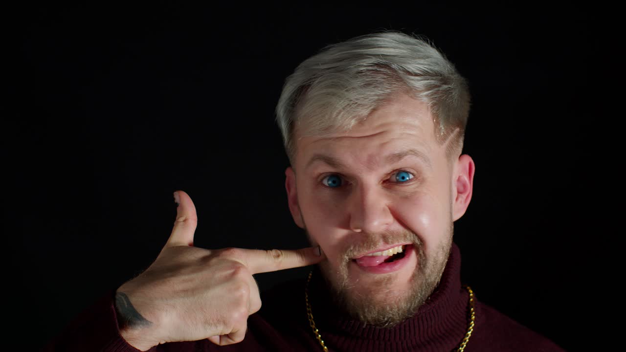 행복하고 세련된 젊은이가 흥분하여 미소 짓고 카메라를 가리키며, 아름다움은 운이 좋은 승자를 선택합니다.