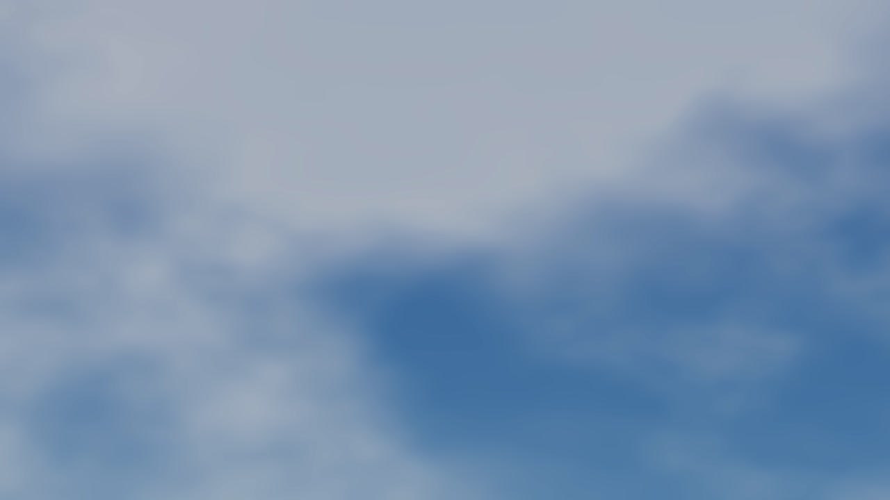 Wispy white clouds drift slowly across a clear blue sky in this organic background animation