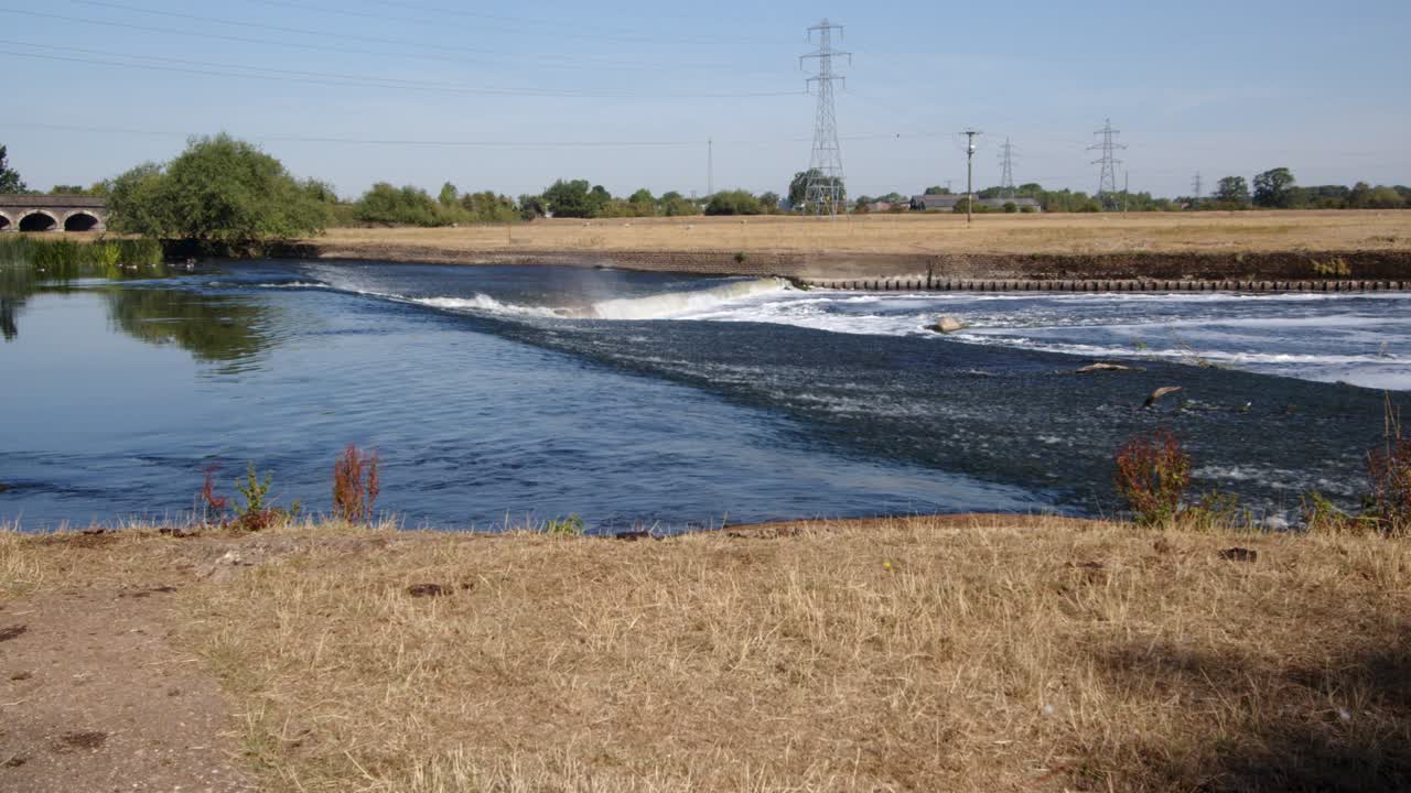 River Trent weir with the Trent Railway line bridge in background, by Ratcliffe on Soar Power station. Wide shot