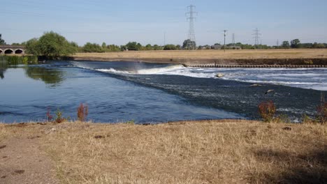 river trent weir with the trent railway line bridge in background, by ratcliffe on soar power station. wide shot