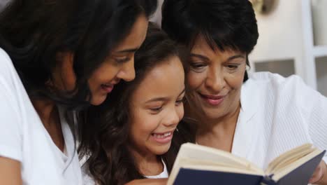 Familia-Multigeneracional-Leyendo-Un-Libro-En-El-Dormitorio-4k