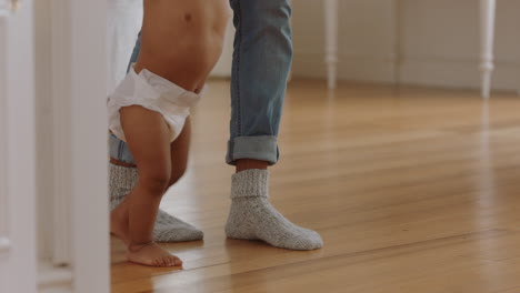 baby learning to walk toddler taking first steps with father helping infant teaching child at home